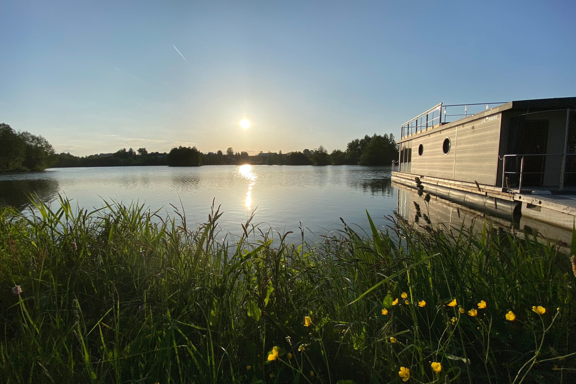 Der blaue See mit dem Hausboot f&uuml;r ihren Chaleturlaub auf dem Wasser.