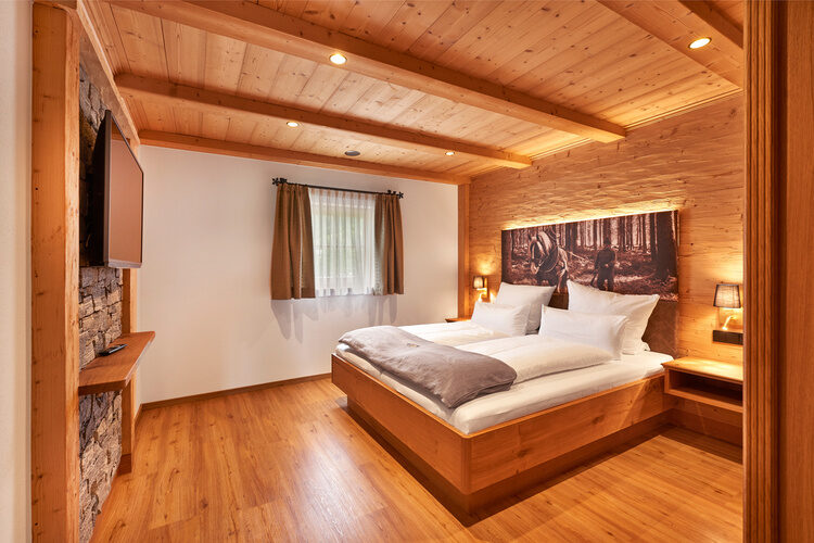 Ein gemütliches Schlafzimmer aus Holz im Chalet Wenighof.