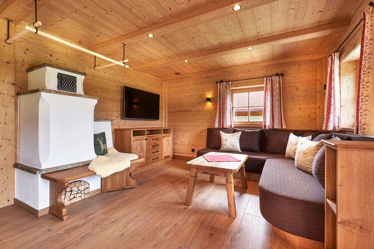 Ein geschmackvoll eingerichtetes Wohnzimmer im Chalet Wenighof mit hölzernen Akzenten und einem komfortablen Sofa.