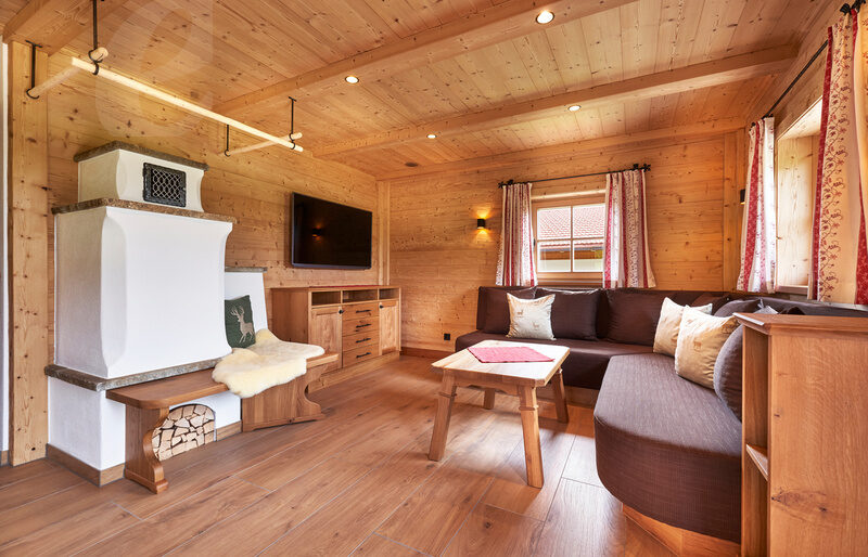Ein geschmackvoll eingerichtetes Wohnzimmer im Chalet Wenighof mit hölzernen Akzenten und einem komfortablen Sofa.