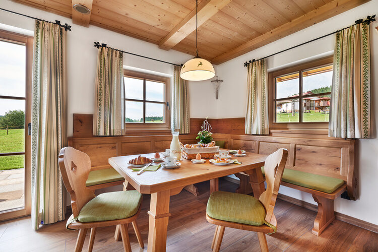 Ein elegantes Esszimmer mit einem Tisch und Stühlen im Chalet Wenighof.