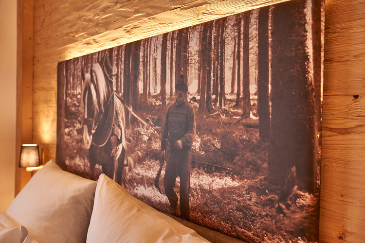 Ein gemütliches Bett im Chalet Wenighof-Schlafzimmer mit einem Gemälde an der Wand.