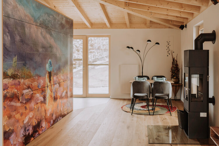 Ein geschmackvoll eingerichtetes Wohnzimmer in Im Waidlerland mit einem gro&szlig;en Gem&auml;lde an der Wand.