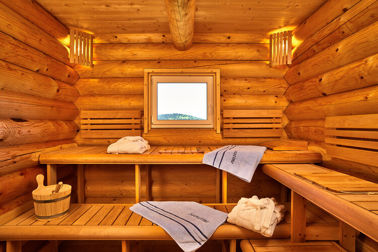 Die Sauna im Chalet Blumental mit Handtüchern und einem kleinen Fenster.