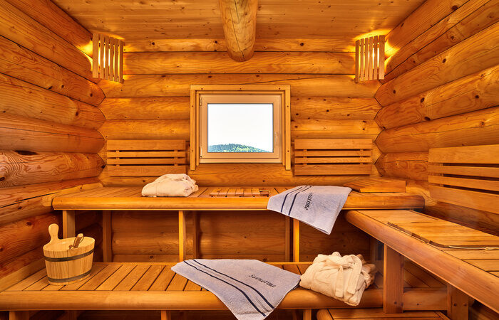 Die Sauna im Chalet Blumental mit Handtüchern und einem kleinen Fenster.