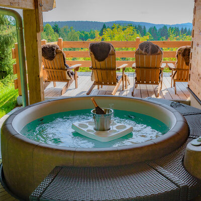 Ein Hot-Tub auf einem hölzernen Deck im Garten von Das Wistlberg.