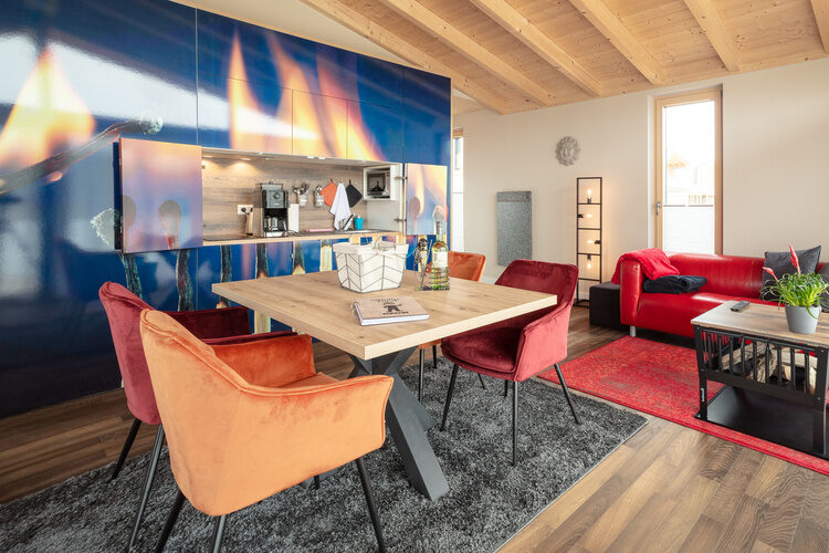 Das Chalet Wohnzimmer mit einem roten Sofa und einer Küche im Flammendesign
