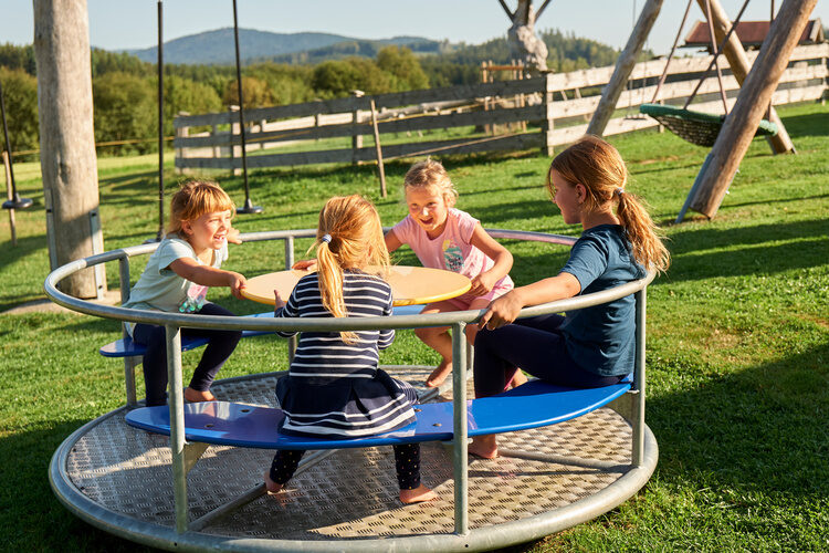 Eine Gruppe von Kindern spielt auf einem Spielplatz beim Chalet Wenighof.