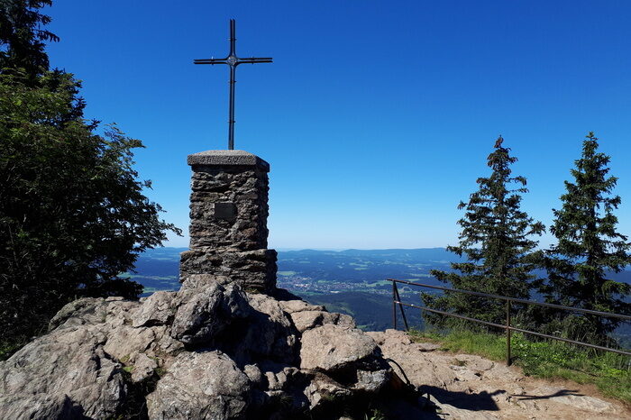 Das Kreuz auf dem Großen Falkenstein umgeben von Fichten.