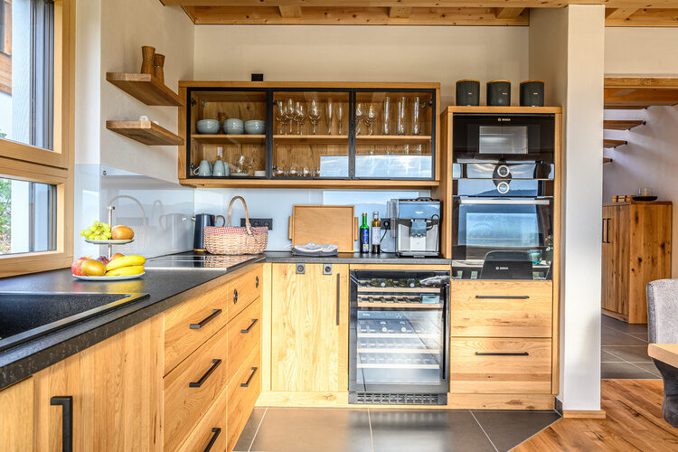 Eine Küche mit Holzkabinetten und schwarzen Arbeitsplatten in den Kroner Chalets.