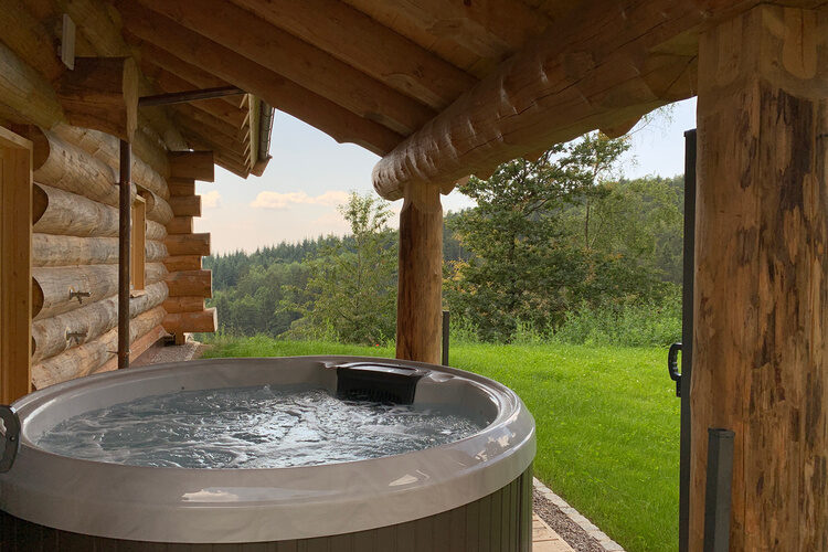 Der Whirlpool im Top Chalet unter einer Überdachung auf der Holzterrasse