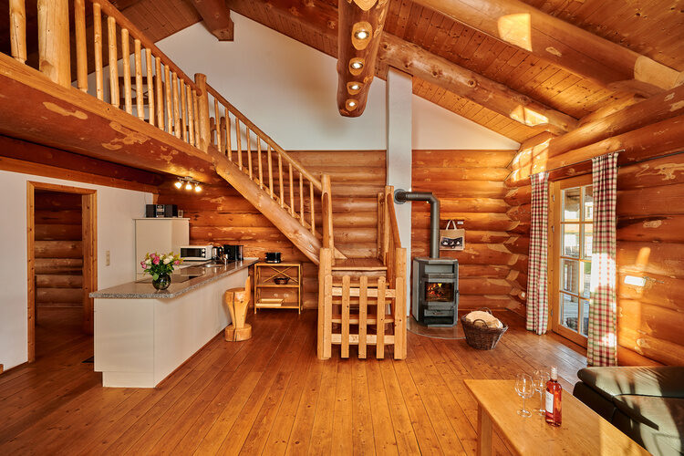 Das Wohnzimmer in einem Laumertal Chalet mit der Treppe zur Galerie.