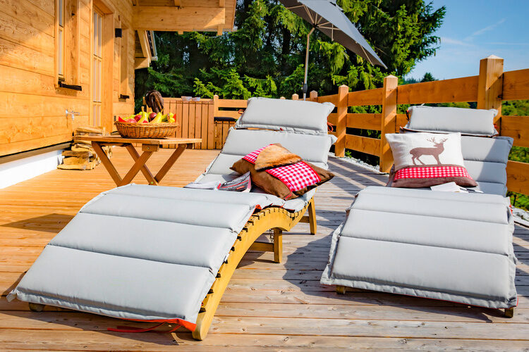 Ein Paar Lounge-Stühle auf einem Holzdeck im Das Wistlberg Chalet.
