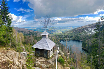 Ein malerischer Blick auf die Rachelkapelle im Nationalpark Bayerischer Wald mit See im Hintergrund