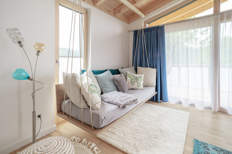Ein Sofa, aufgehängt an Seilen, im modernen Wohnzimmer des Chalets.