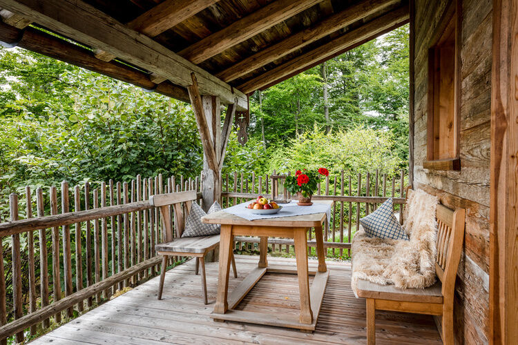 Terrasse mit Tisch und Bänken und Luxus Chalet Bayerischer Wald