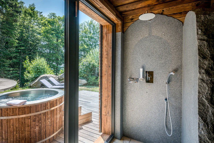 Dusche mit Blick auf die Terrasse mit Whirlpool des Luxus Chalets Bayern