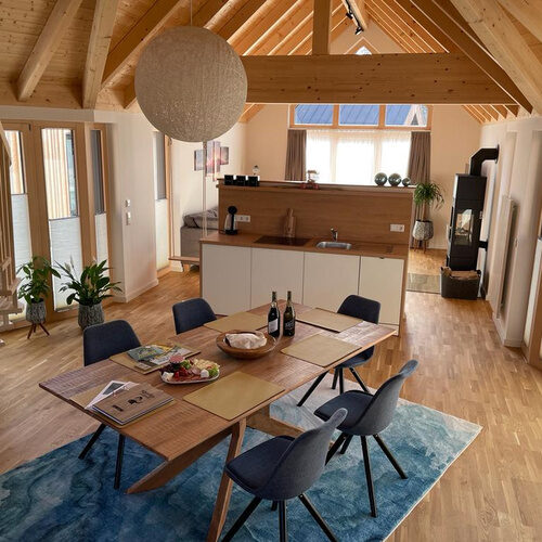 Ein Esszimmer im Chalet mit moderner Einrichtung und gro&szlig;en Fenstern.
