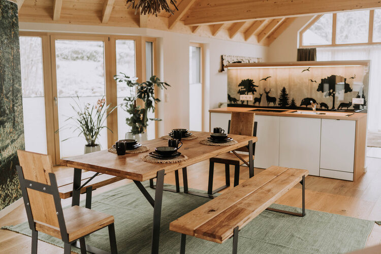 Ein Holztisch und zwei B&auml;nke im rustikalen Design eines Speiseraums im Bayerischen Wald