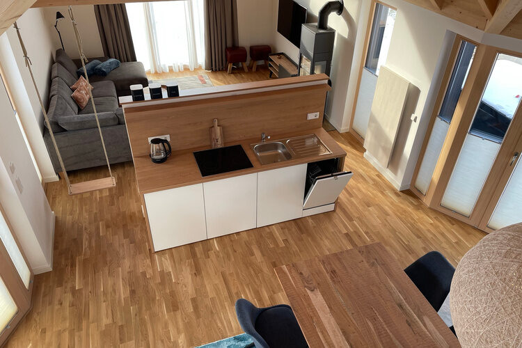 Ein luftiges Wohnzimmer und K&uuml;che in einem Chalet Im Waidlerland mit stilvollem Interieur.