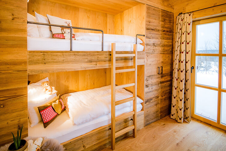 Ein Etagenbett in einem Schlafzimmer von Das Wistlberg mit Holzverkleidung.